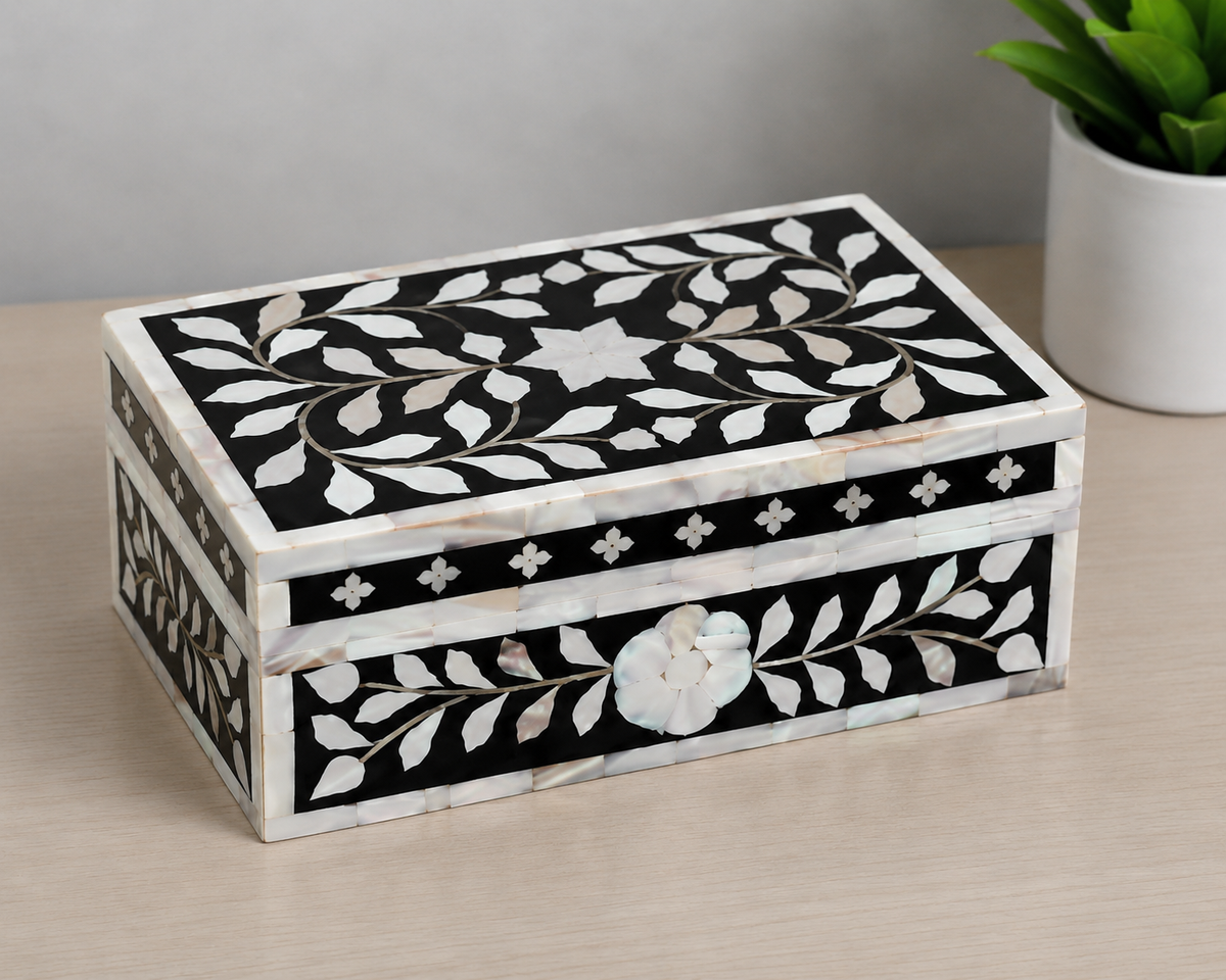 Top view of rectangular black mother of pearl inlay box with floral vine pattern.