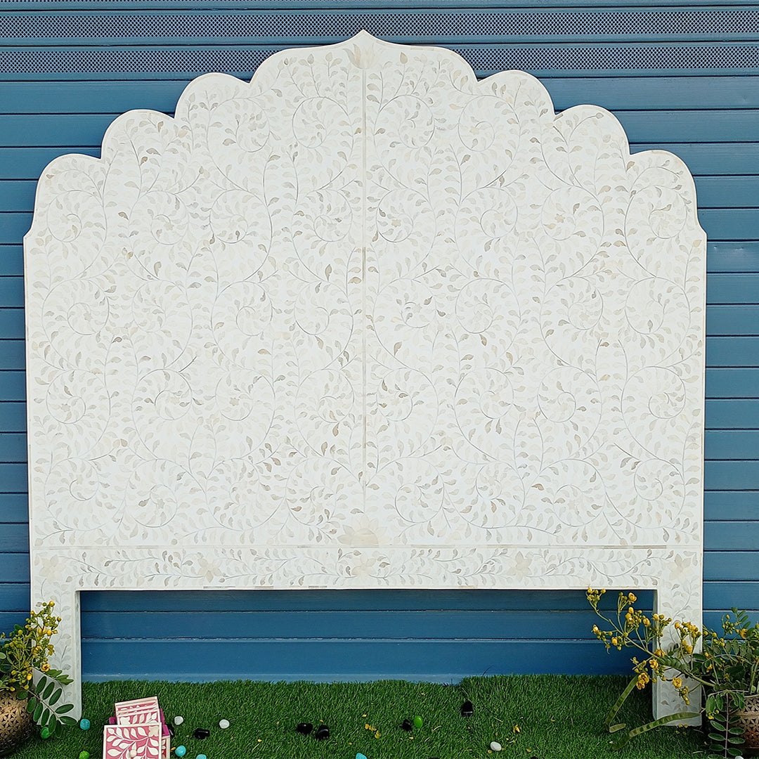 Angled view of luxury white bone inlay headboard featuring handcrafted floral inlay and elegant scalloped silhouette.
