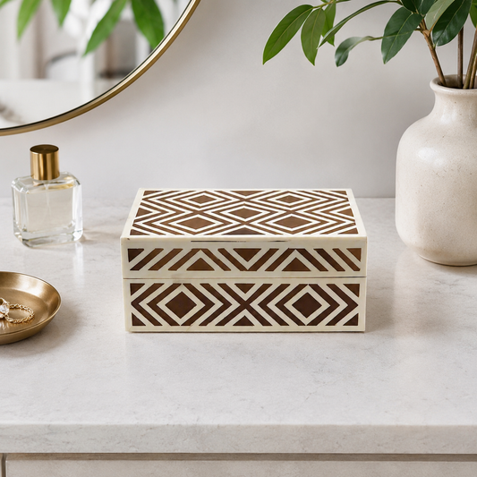 Luxury handmade bone inlay geometric jewelry box styled on a modern vanity table with perfume and decorative accents.