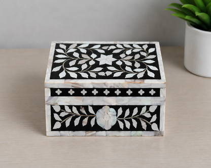 Detailed macro shot of black mother of pearl keepsake box showcasing floral craftsmanship.