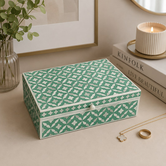 Handcrafted teal bone inlay jewelry box with Moroccan pattern styled on a modern vanity table with decorative books, candle, greenery, and gold jewelry.