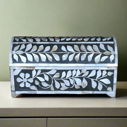 Front view of handmade mother of pearl jewelry box with floral vine inlay and curved lid