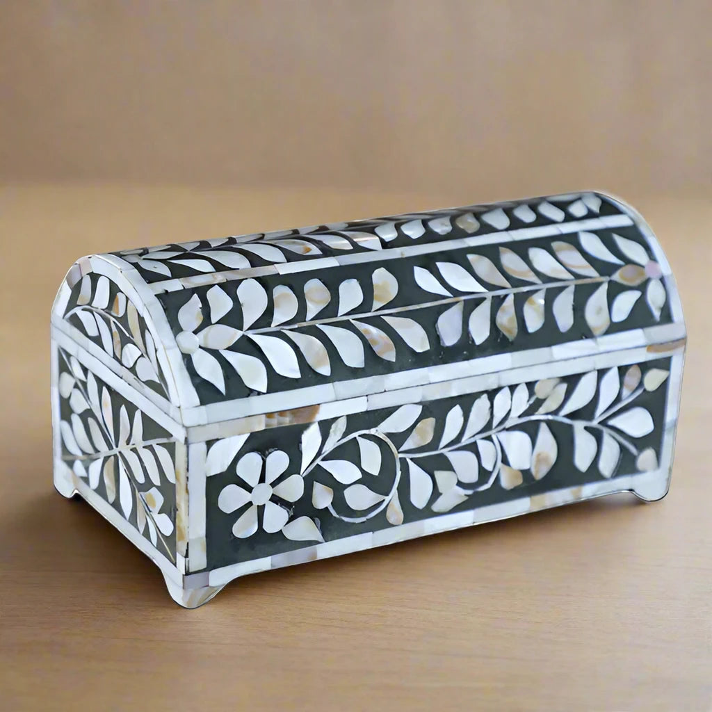 Open mother of pearl inlay jewelry box with black velvet interior and floral pattern