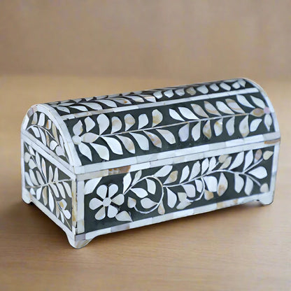 Open mother of pearl inlay jewelry box with black velvet interior and floral pattern