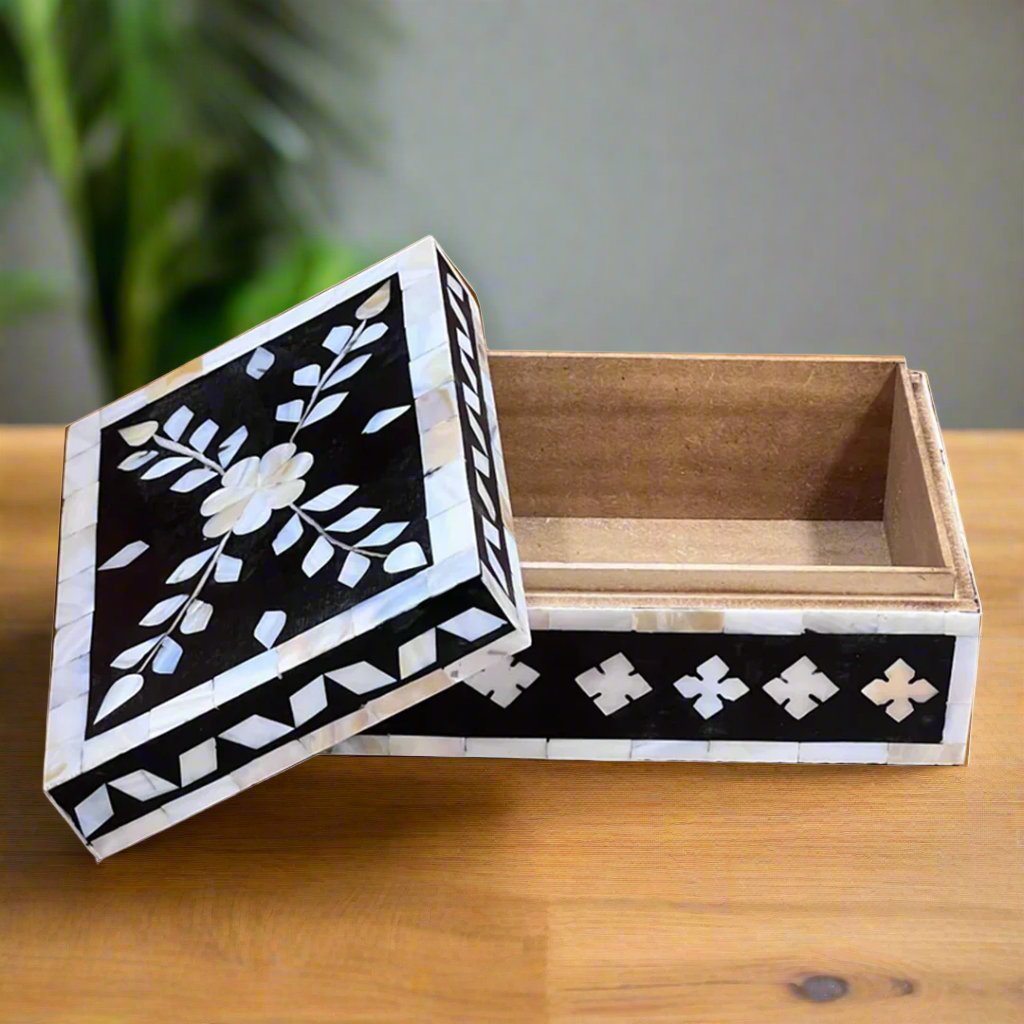 Artisan-crafted black jewelry box with floral and leaf inlay.