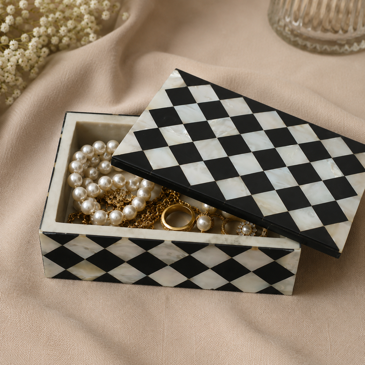 Decorative Mother of Pearl inlay jewelry box with diamond pattern, partially open to reveal luxury jewelry.