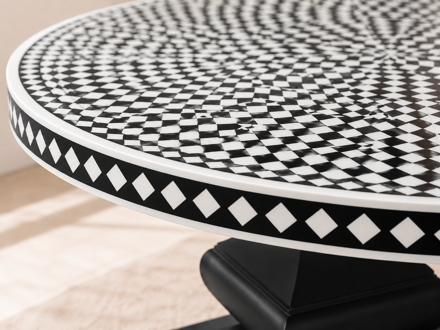 Designer round bone inlay dining table with black pedestal base in a sophisticated contemporary dining space.