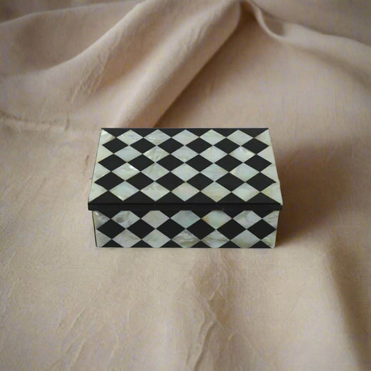 Handmade Mother of Pearl inlay jewelry box with black geometric diamond pattern and pearl jewelry inside.