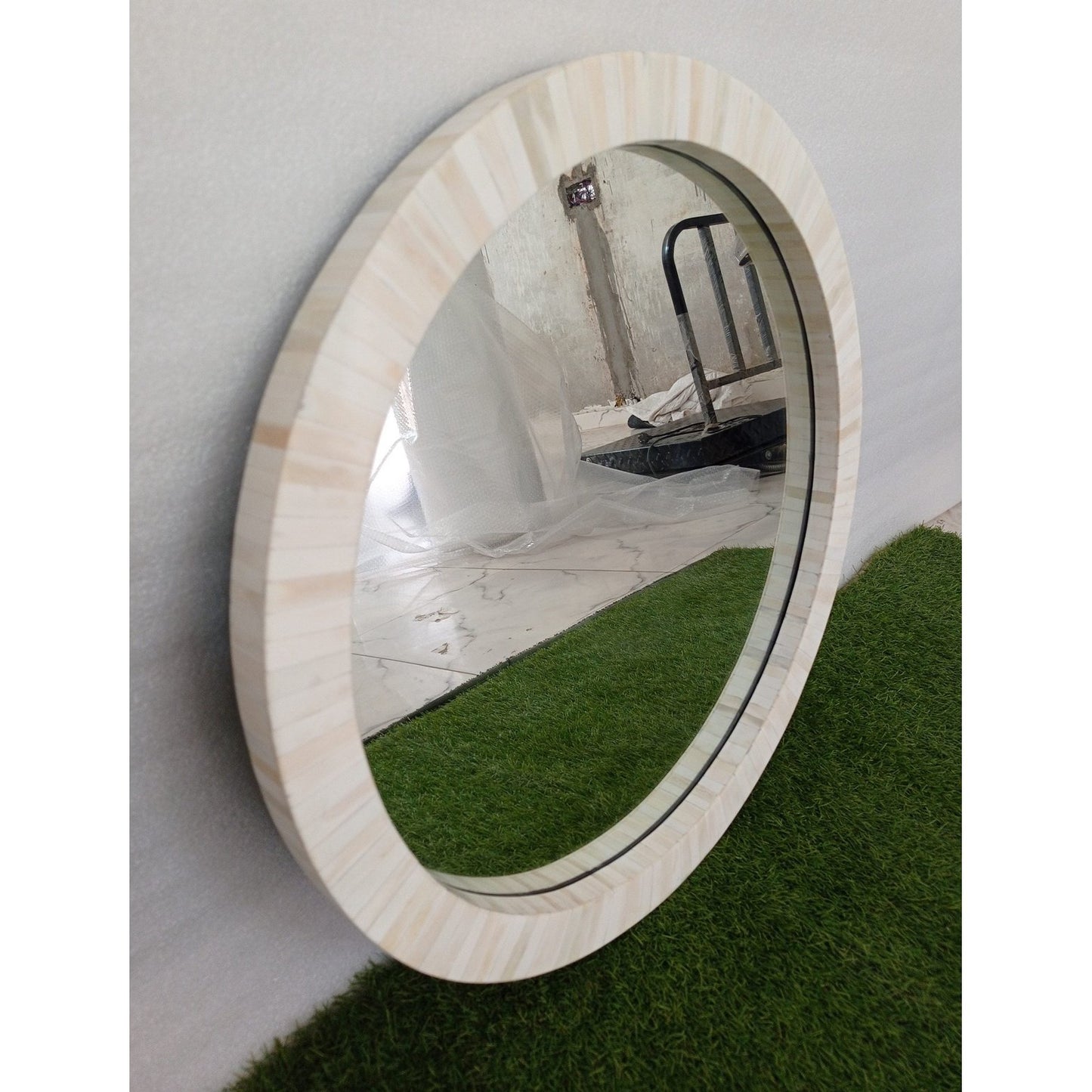 Decorative round bone inlay mirror in a minimalist modern hallway with designer console table.